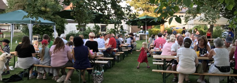 Viele Menschen feiern im Gemeindegarten